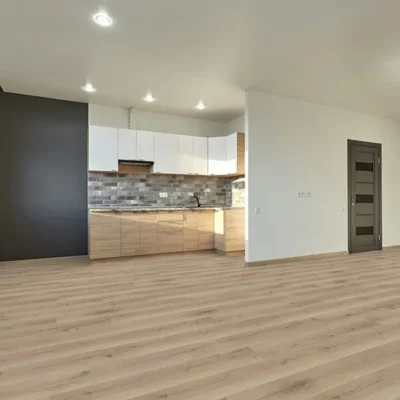AGT Natura Ilgaz laminate flooring installed in a modern open-plan kitchen and living area with natural oak tones